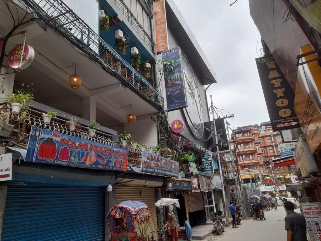 uma rua em uma cidade asiática com pessoas andando pela rua em Imperial House em Kathmandu
