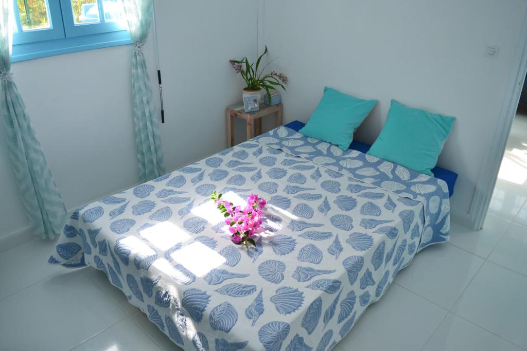 a bedroom with a bed with flowers on it at LOGEMENT AZUL à l'ombre du bambou 1 à 3 pers, Réserve Cousteau in Le Gosier