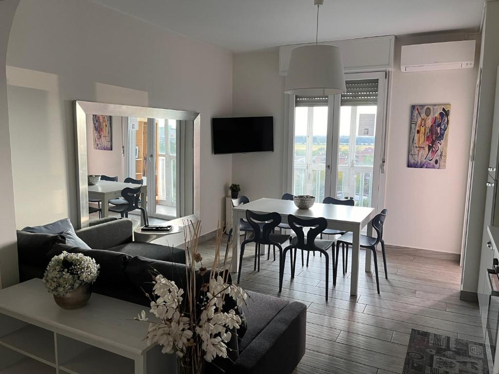 ein Wohnzimmer mit einem Sofa und einem Tisch mit Stühlen in der Unterkunft Appartamento panoramico vicino a fiere e stadio in Mailand