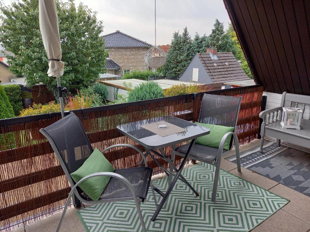 a patio with a table and chairs and an umbrella at Ferien zwischen den Meeren in Jübek