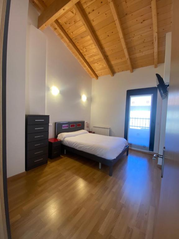 1 dormitorio con 1 cama y suelo de madera en Vivienda de uso Turístico - La Garnacha en Rodezno