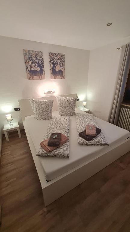 a white bed with two plates on top of it at Ferienwohnung Ertner in Füssen