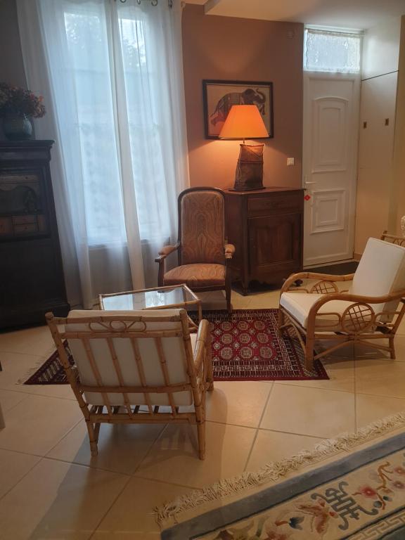 a living room with two chairs and a table at Maison Saloine in Saintes