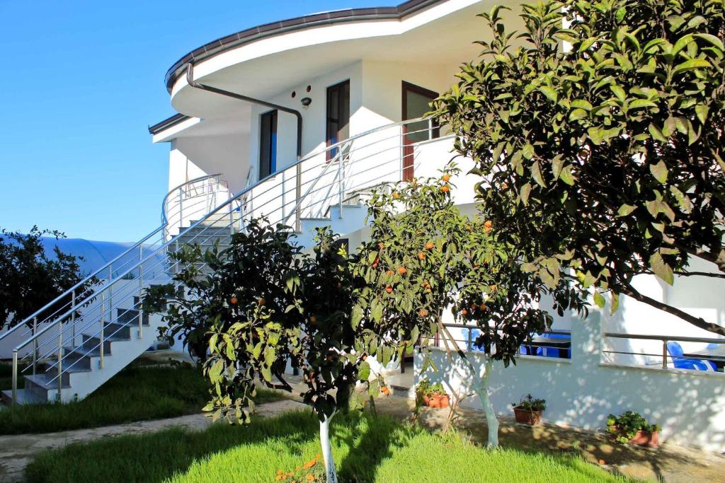 a white house with a tree in front of it at Hasler Studios in Qerret