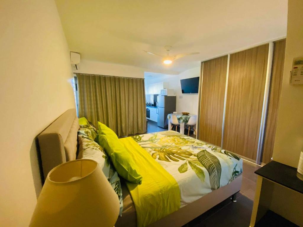 Tehautahi Cozy Lodge 2 في بابيت: غرفة نوم بسرير مع لحاف اصفر