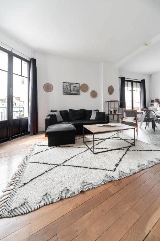 a living room with a black couch and a table at Residence Le Paris - 57b Rue de Paris - Vichy in Vichy