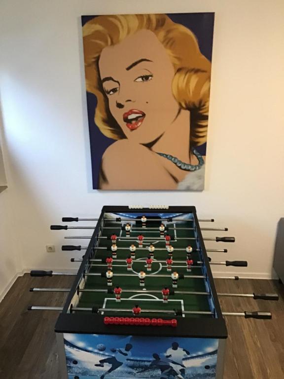 a pool table in front of a painting at VerwöhnWohnungDeluxe in Wuppertal