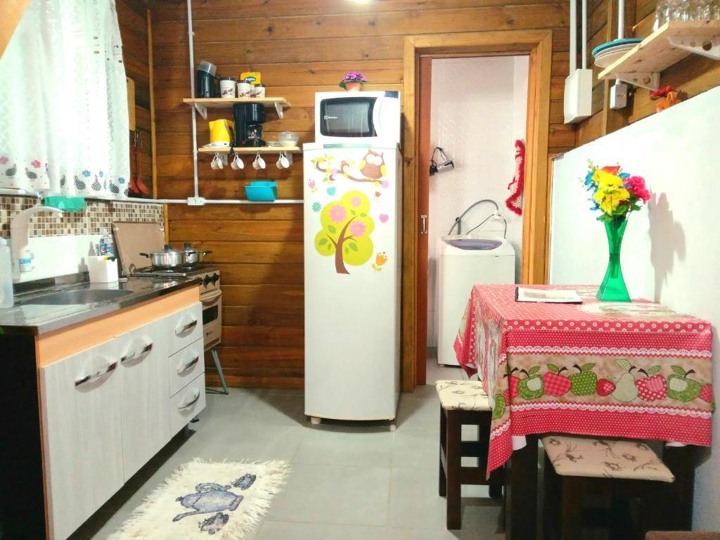 a kitchen with a refrigerator and a table in it at Tiny House moçambique - Sua casinha em Floripa! in Florianópolis
