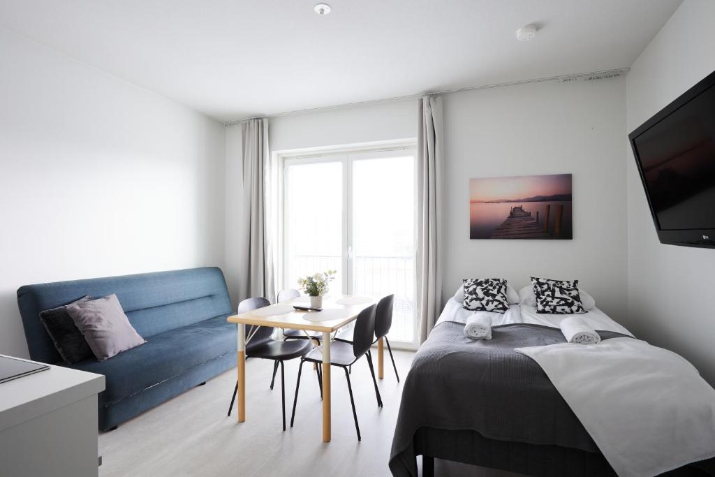 - une chambre avec un lit, une table et un canapé dans l'établissement 7.kerroksen huoneisto, Wifi + 24/7 check in, à Turku