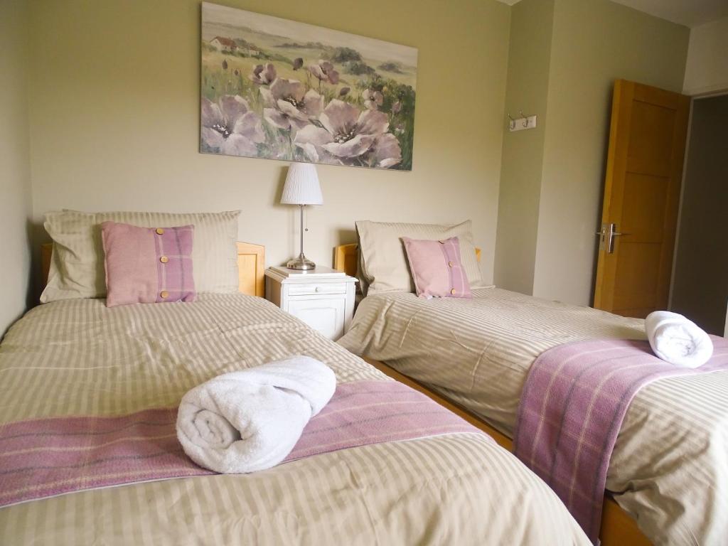 a bedroom with two beds with towels on them at Woldsend in Moreton in Marsh