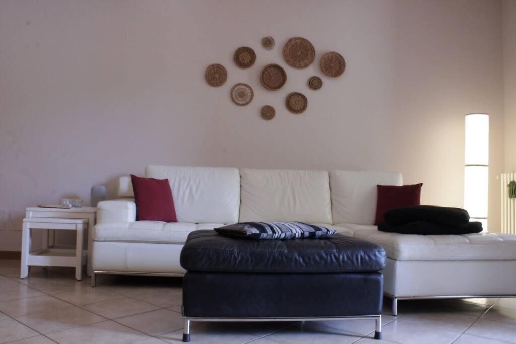 a living room with a white couch and a stool at Sweet Home en Arquá Petrarca in Arquà Petrarca