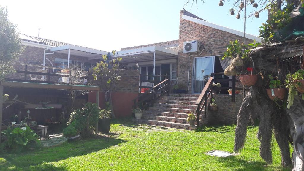 a house with a yard with stairs and plants at TOEVLUG in Gansbaai