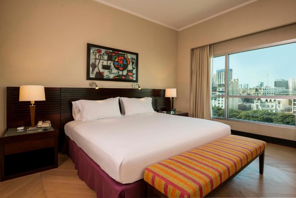 a bedroom with a large bed and a large window at Eurobuilding Hotel Boutique Buenos Aires in Buenos Aires