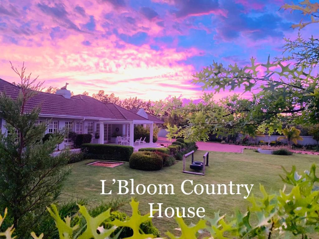 ein Haus mit Sonnenuntergang in einem Hof mit den Worten blühender Ferienhof in der Unterkunft L'Bloom Country House in Tulbagh