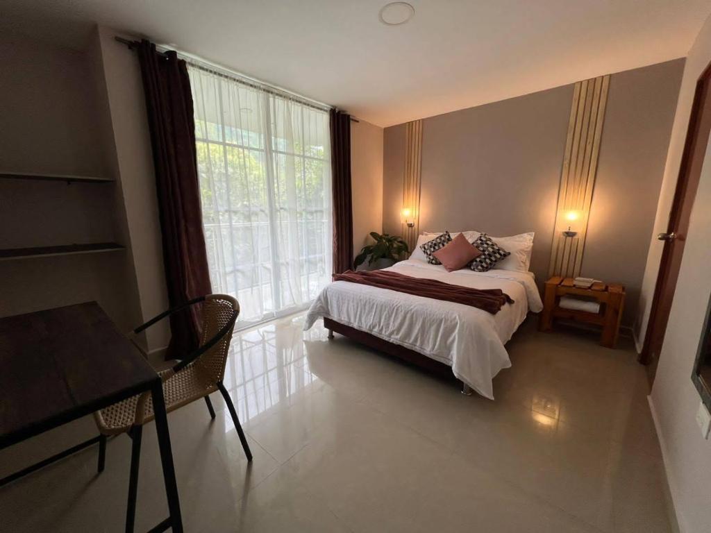 1 dormitorio con cama y ventana grande en Montes De Beraka, en Minca