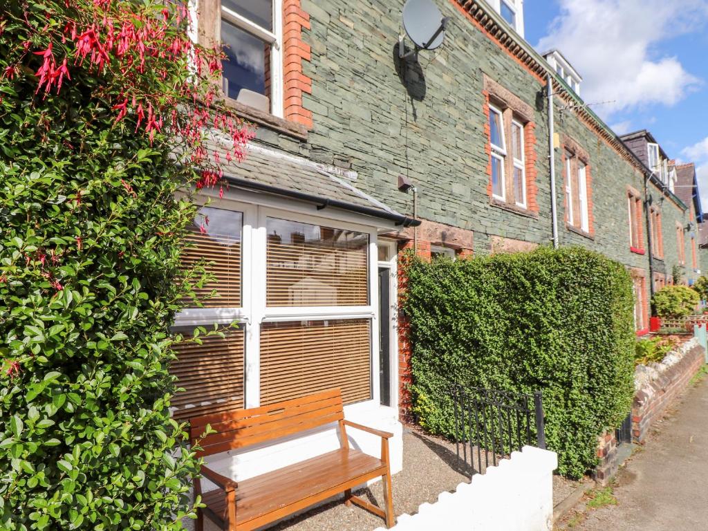 een houten bank voor een gebouw bij Archers in Keswick