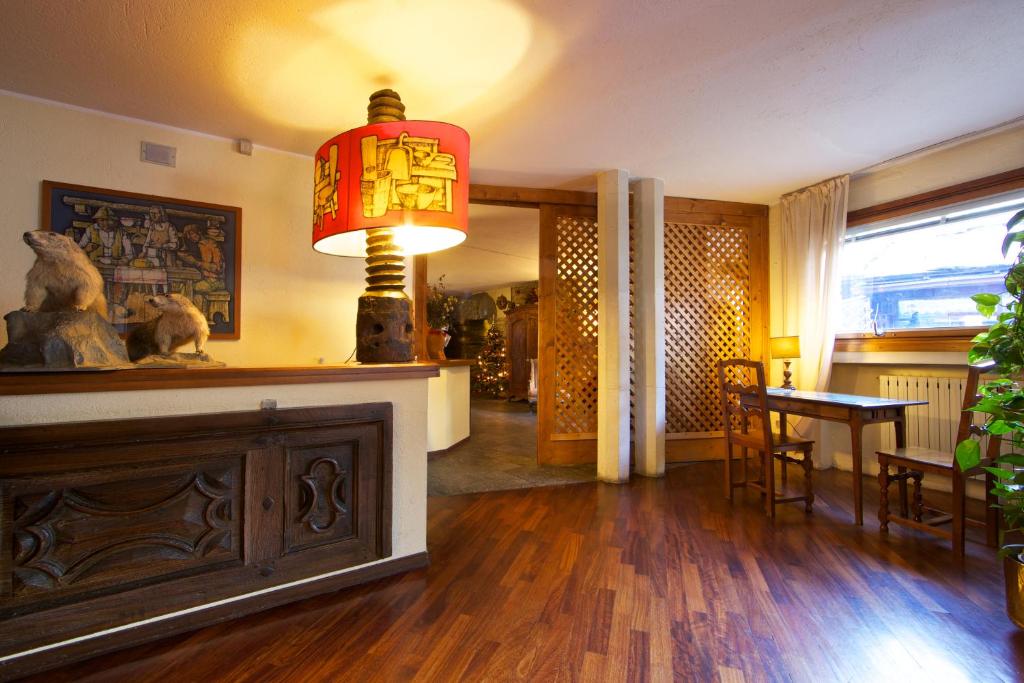 a living room with a table and a lamp at Hotel Dolonne in Courmayeur