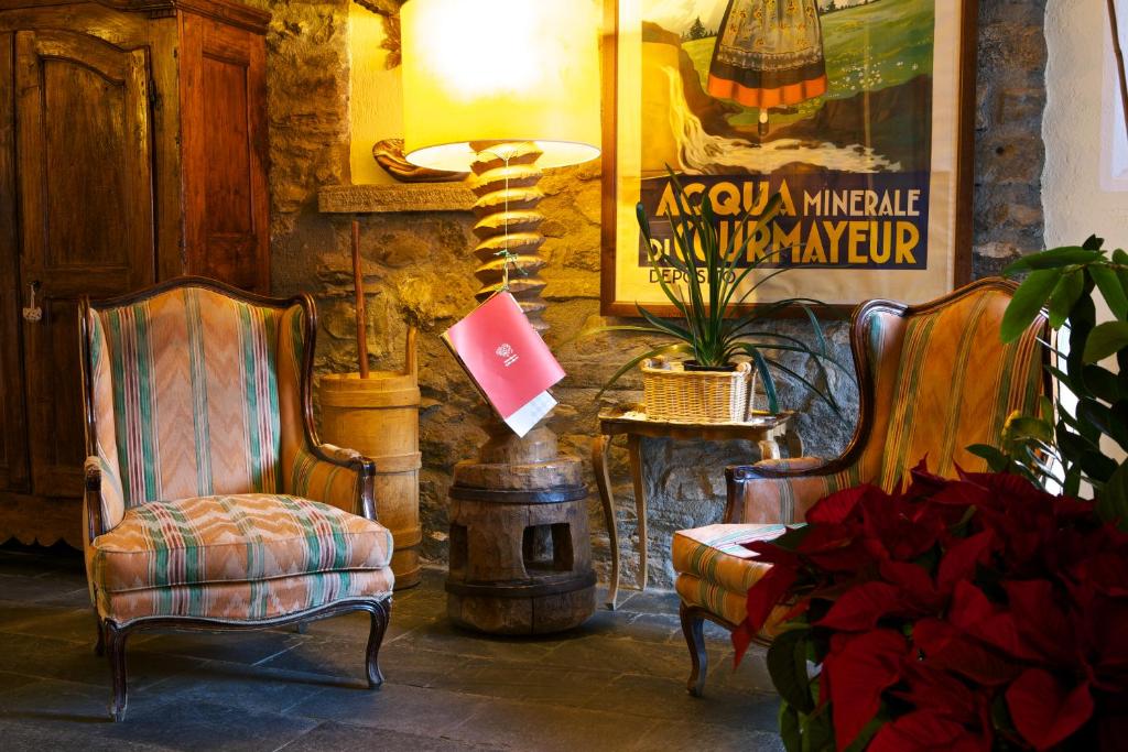 a living room with two chairs and a fireplace at Hotel Dolonne in Courmayeur