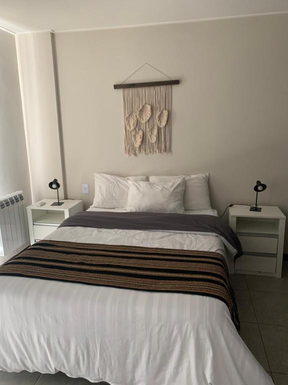 1 dormitorio con 1 cama grande y 2 mesitas de noche en Departamento céntrico, pileta cochera moderno y lujoso en Villa Carlos Paz