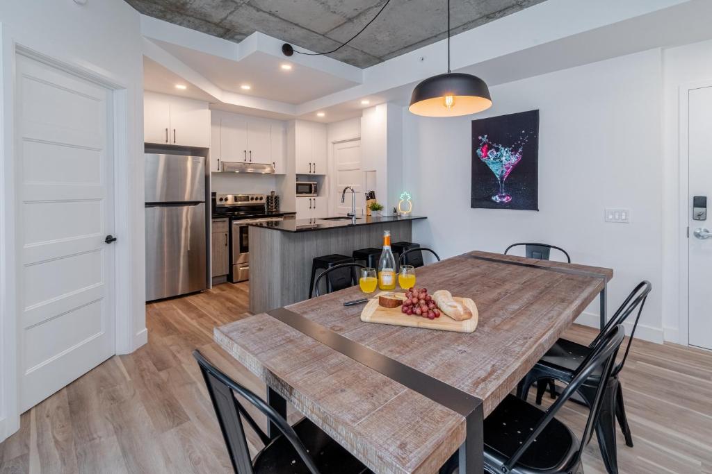 eine Küche und ein Esszimmer mit einem Holztisch und Stühlen in der Unterkunft 2 Bedroom condo - 800M of Old Quebec ! in Québec
