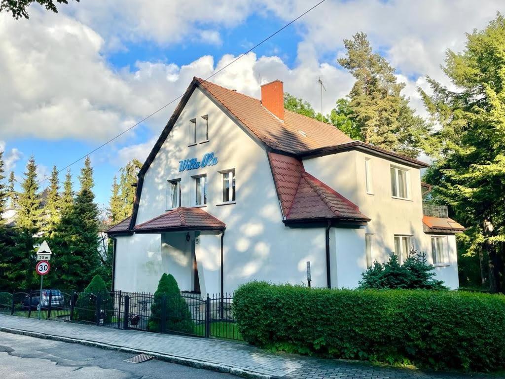 une maison blanche avec un toit rouge dans l'établissement Villa Ola, à Polanica-Zdrój