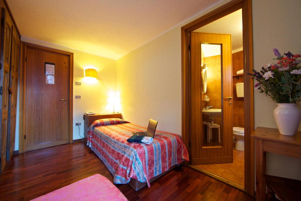 a bedroom with a bed with a laptop on it at Hotel Dolonne in Courmayeur