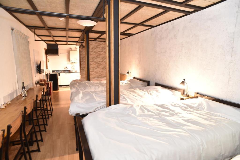 1 dormitorio con 1 cama grande con sábanas blancas en Motel inn Minami Otaru / Vacation STAY 50444, en Otaru