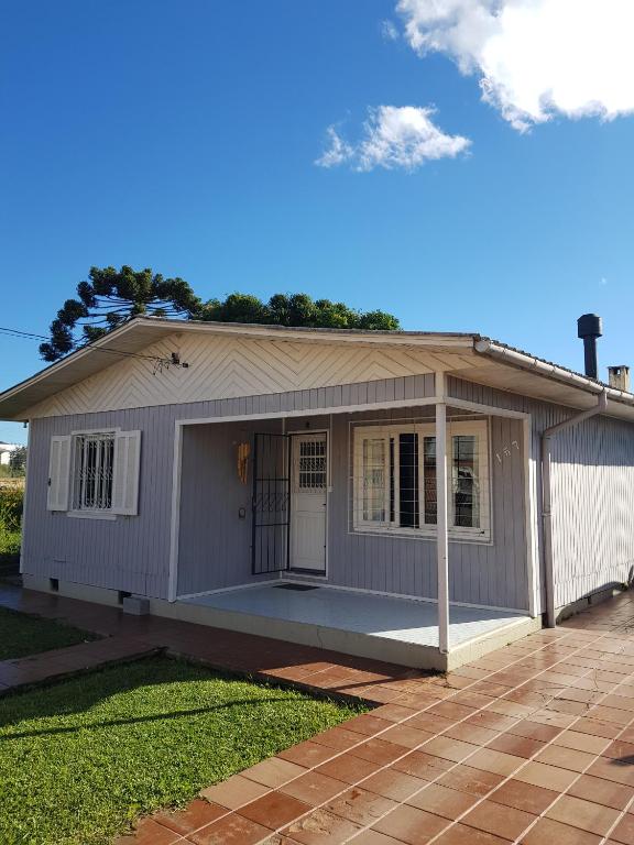 a small house with a porch and a garage at CASA FULL CENTRAL, 130m quadr, 9 Pessoas, Wi-Fi, 3 Qtos, Churrasqueira Interna, Cozinha-Sala Integrados, 2 Banheiros, Varanda, Jardim, Garagem Coberta 1 Carro, Estac Inter 3 Carros, Lareira de Alta Performance, Fogão de Ferro, Área nos Fundos in Cambará