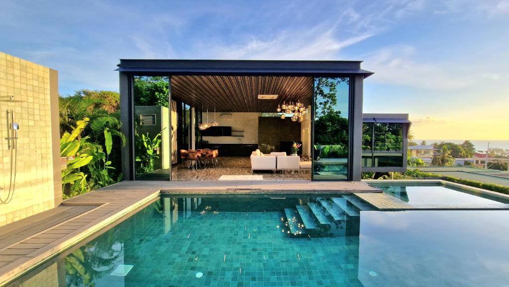 einen Infinity-Pool in einem Haus mit einem Wohnzimmer in der Unterkunft Villa Obsidian, with staff, sea view and walk to Choeng Mon beach in Strand Choeng Mon