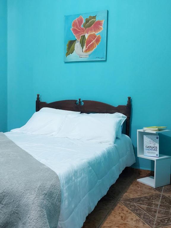 a bedroom with a bed with a blue wall at Triunfo Flat in Triunfo