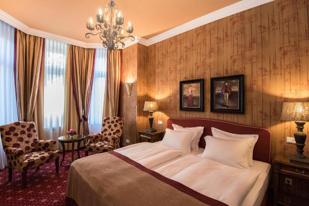 a hotel room with a bed and a chandelier at Hotel City House in Hamburg