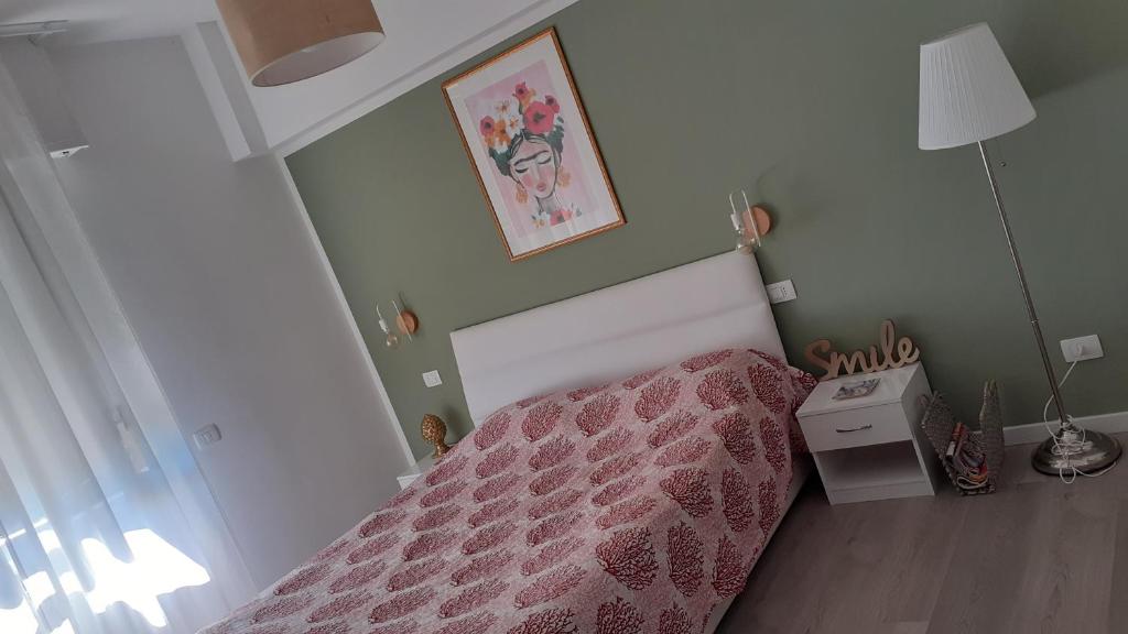 Dormitorio pequeño con cama con colcha rosa en Casa di Kiki, en Finale Ligure