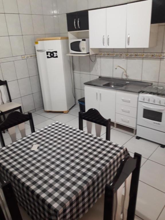 a kitchen with a table with a checkered table cloth at Apartamentos C. Santos in Penha