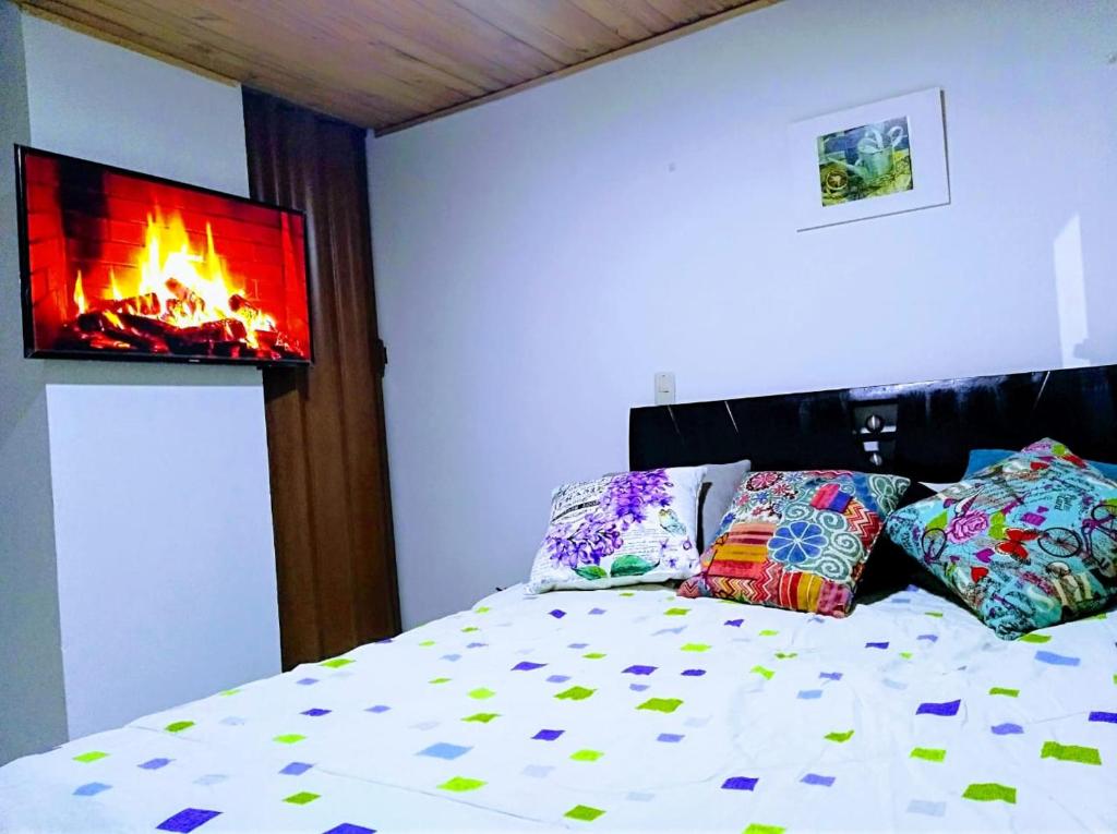 1 dormitorio con 1 cama y chimenea en la pared en HABITACION EN SUBA en Bogotá
