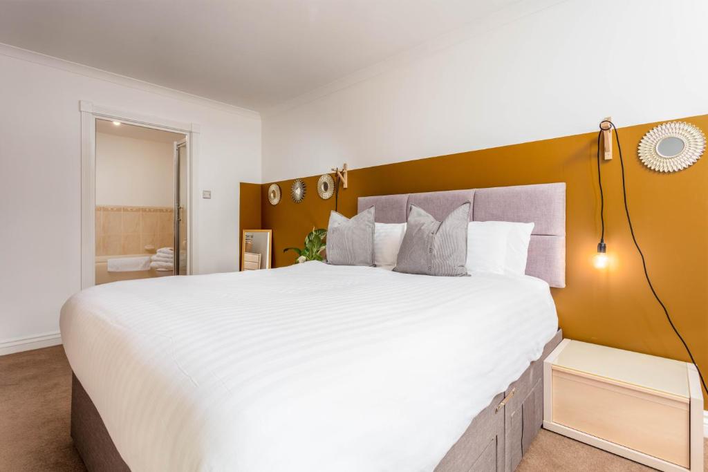 um quarto com uma grande cama branca e uma grande cabeceira de cama. em Turnberry accommodation em Turnberry