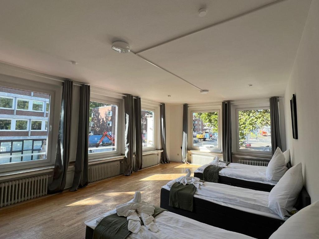 ein Hotelzimmer mit 2 Betten und Fenstern in der Unterkunft Shared Apartment at Heumarkt, City Center in Köln
