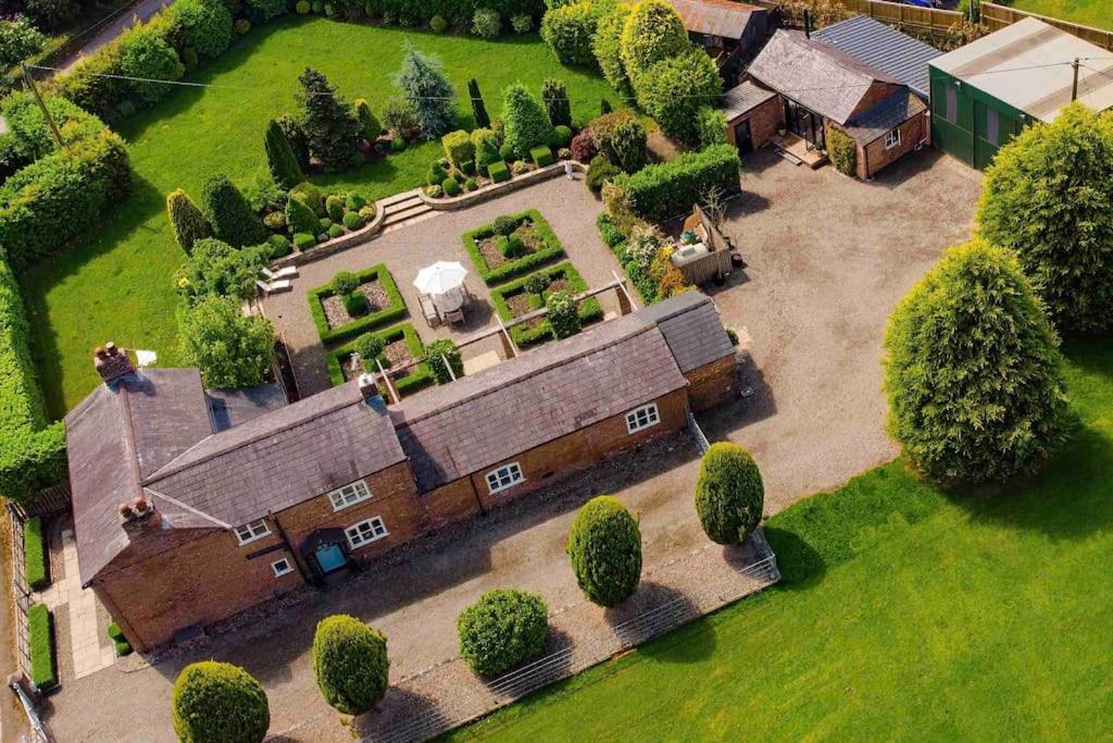 an aerial view of an old building with a yard at Luxury Barn with Hot Tub, Spa Treatments, Private Dining in Little Budworth