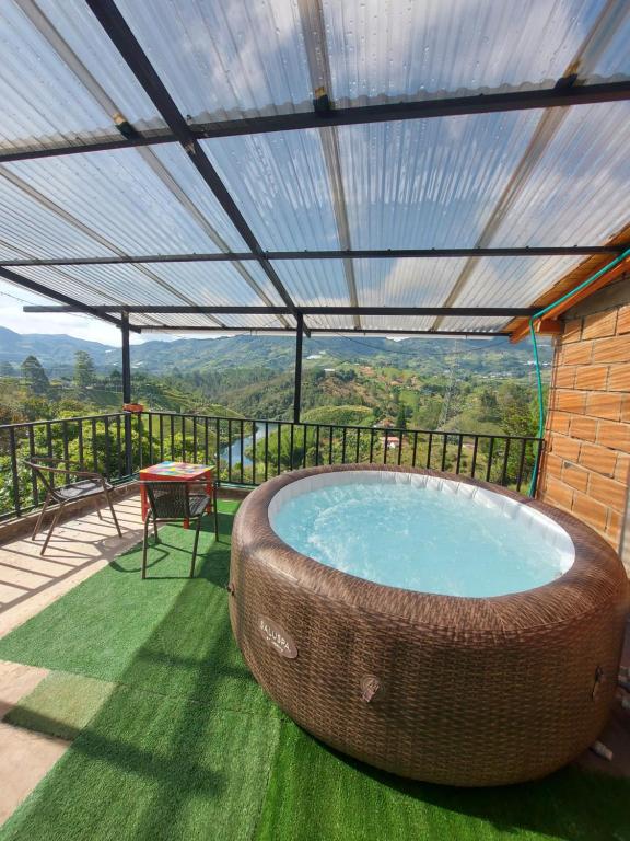 una gran bañera de hidromasaje al aire libre con techo y mesa en Donde Andres Campestre - Guatape en El Peñol