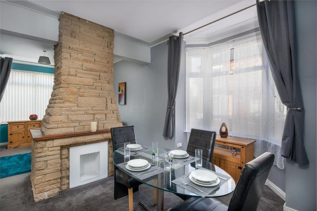 a dining room with a table and a fireplace at Spacious town house free parking and Wi-Fi in Thornaby on Tees