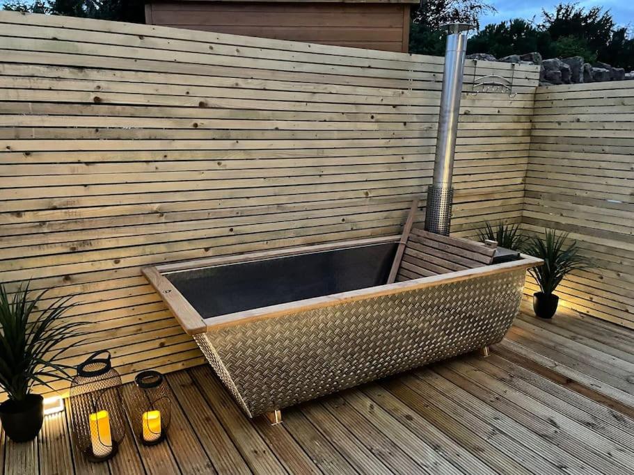 a large planter sitting on a wooden deck at Hill Garth Cottage - Luxury hotel style 2 bed with hot tub in Wooler