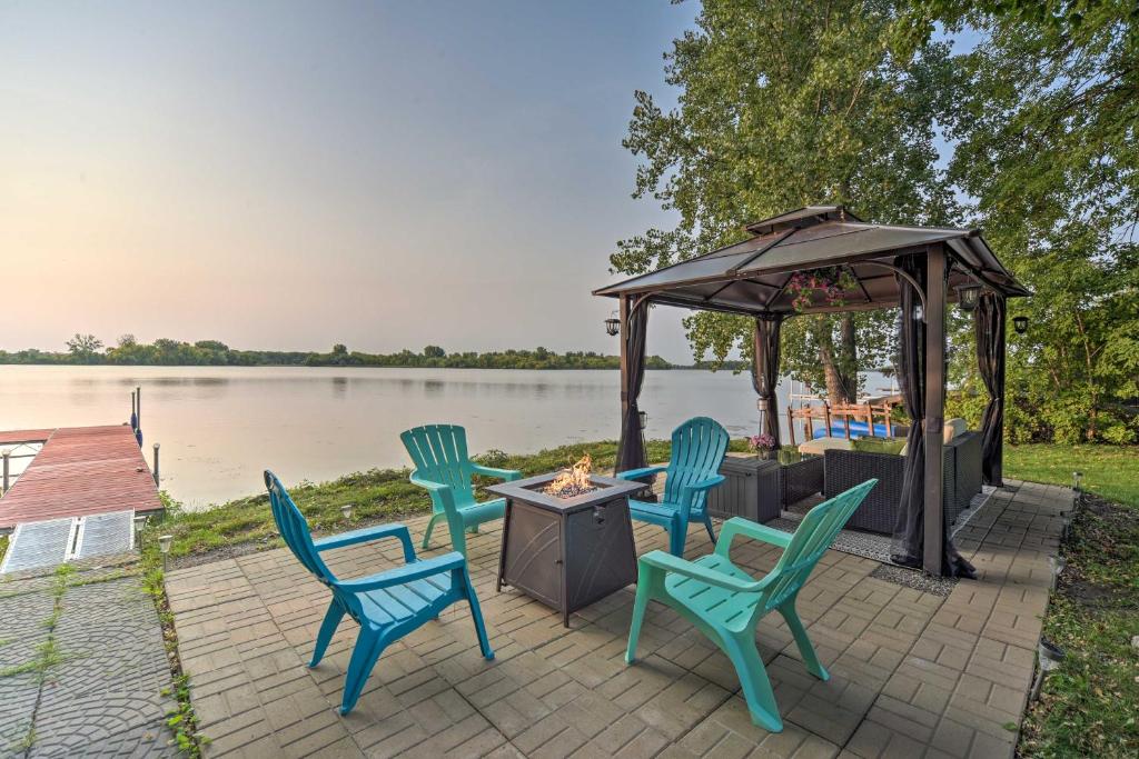 a patio with chairs and a gazebo next to a lake at Hugo Home, Direct Lake Access and Private Dock! in Hugo