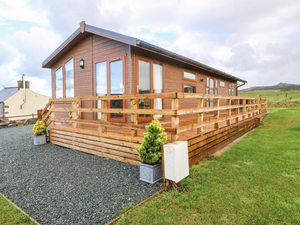 a wooden cabin with a fence around it at Ysgo Lodge in Pwllheli