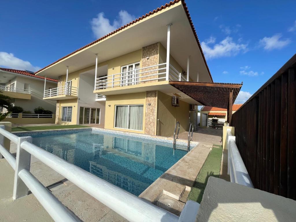 a villa with a swimming pool in front of a house at Villa164 - Luxo, Piscina e Ginásio à beira-mar in Santa Maria