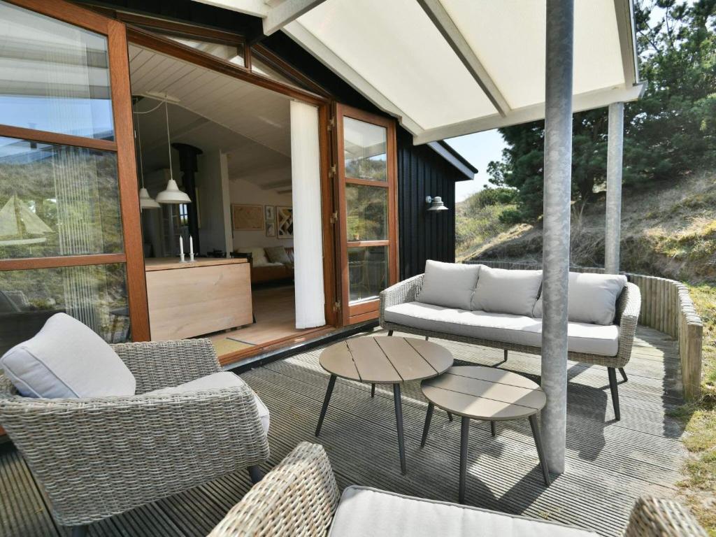 patio con divani e tavolo su una terrazza di Holiday home Fanø CLXXVI a Fanø