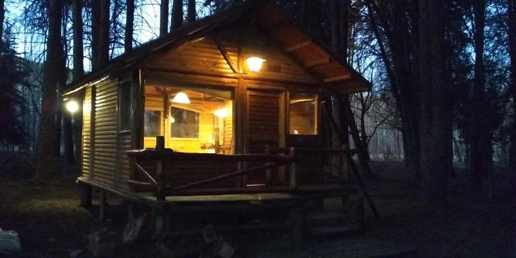 uma pequena cabana de madeira na floresta à noite em Cabaña de Duendes em San Rafael