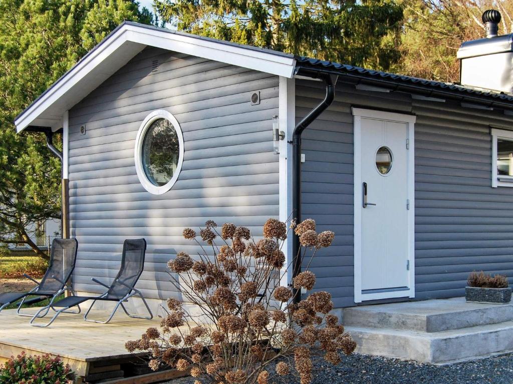 a small blue shed with two chairs and a door at 4 person holiday home in L DDEK PINGE in Löddeköpinge