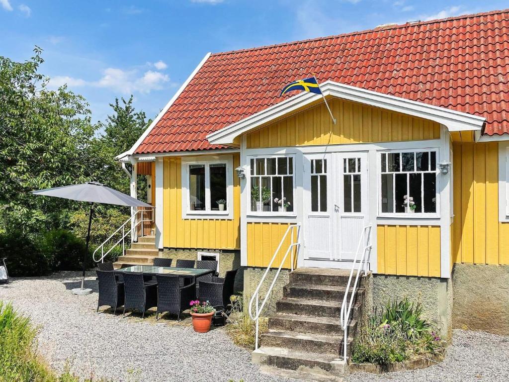 una pequeña casa amarilla con techo rojo en Holiday home KARLSKRONA III, en Karlskrona