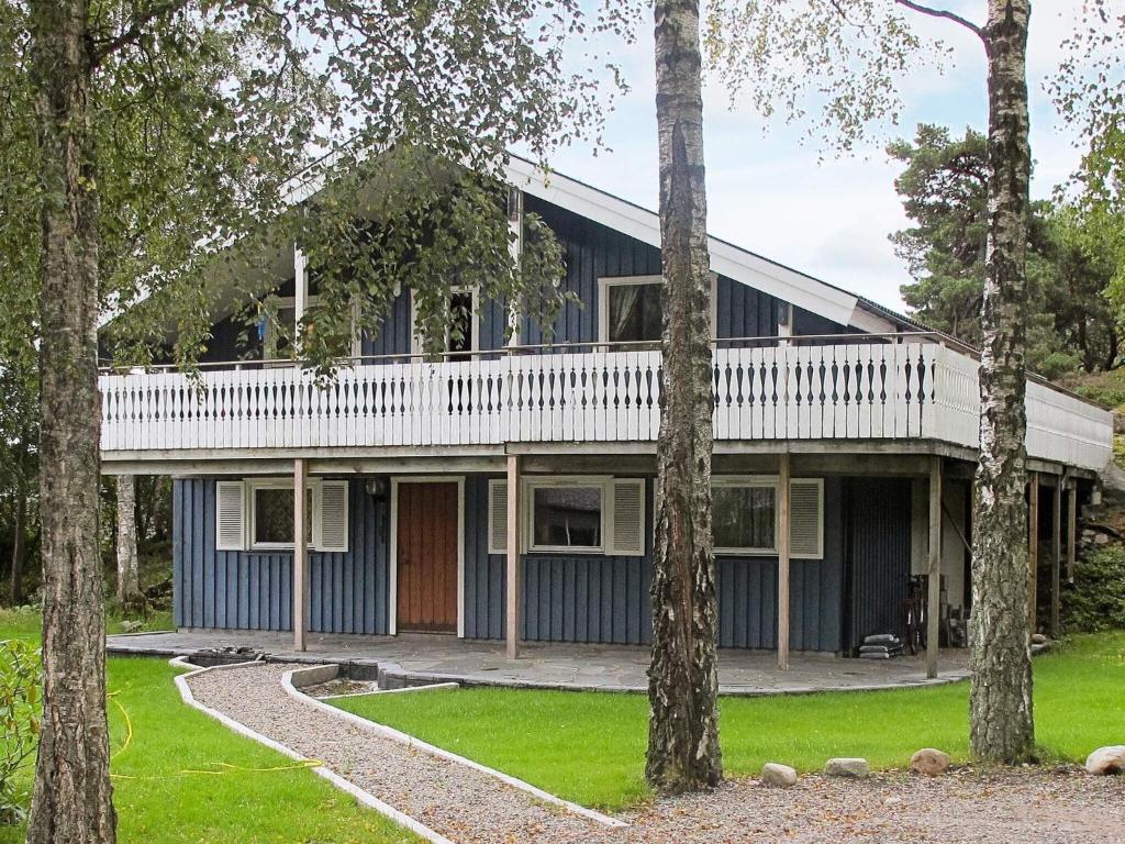 une maison bleue avec un balcon blanc et des arbres dans l'établissement 6 person holiday home in STR MSTAD, à Strömstad