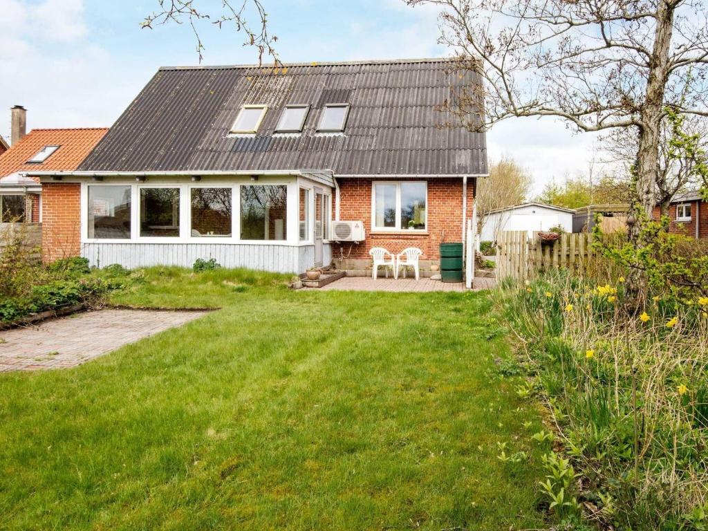 ein Haus mit einem Garten mit grünem Gras in der Unterkunft 6 person holiday home in Ringk bing in Ringkøbing