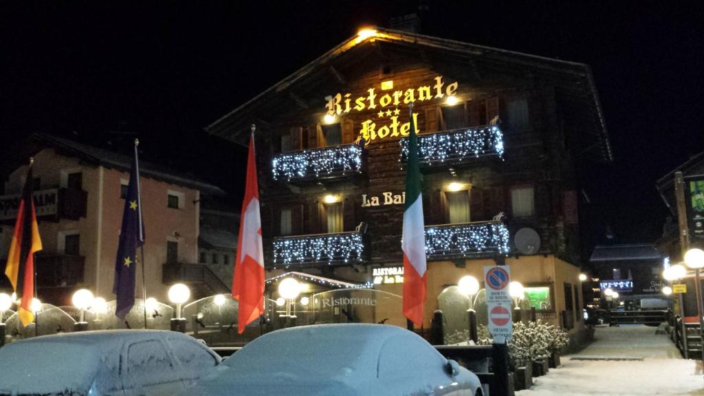 un edificio con un cartel en la nieve en Hotel La Baita en Livigno